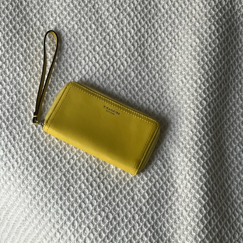 Small yellow zip around Coach wristlet